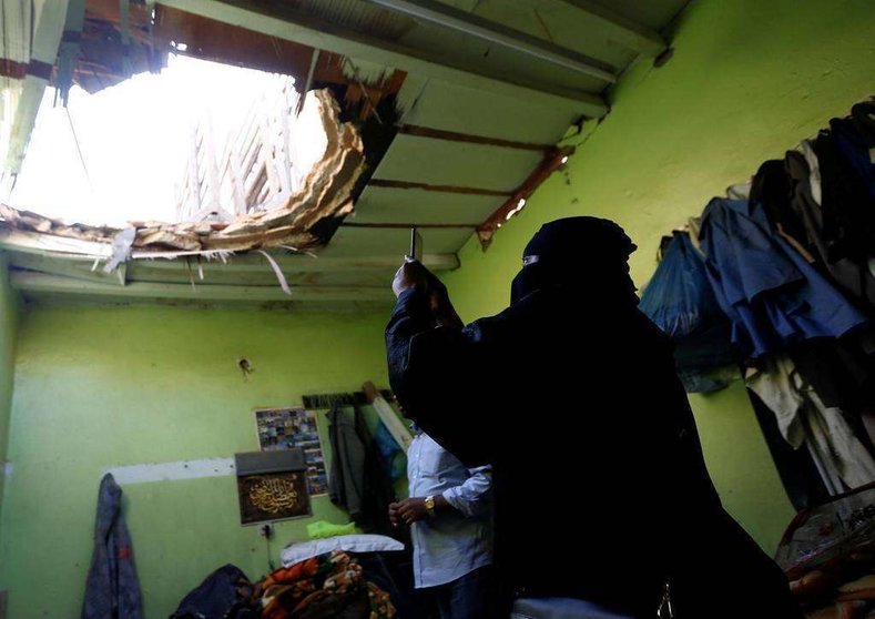 En la imagen de Reuters, una saudí fotografía los desperfectos en una vivienda de los restos del misil lanzado contra Riad.