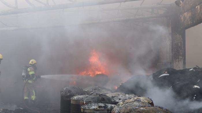 Un bombero actúa contra el fuego en una fábrica de neumáticos del área industrial de el área industrial de Umm Al Thuoob. (Defensa Civil de Umm Al Quwain)