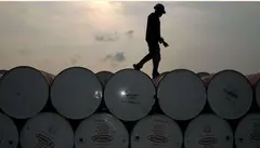 Un trabajador camina por barriles de petr&oacute;leo. (Fuente externa)