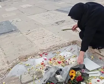 Una mujer deposita flores en el lugar de la muerte de un joven en Teher&aacute;n. (X)