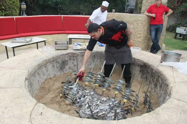 Preparando los espetos de sardina en la terraza del Seville's en Dubai. (EL CORREO)