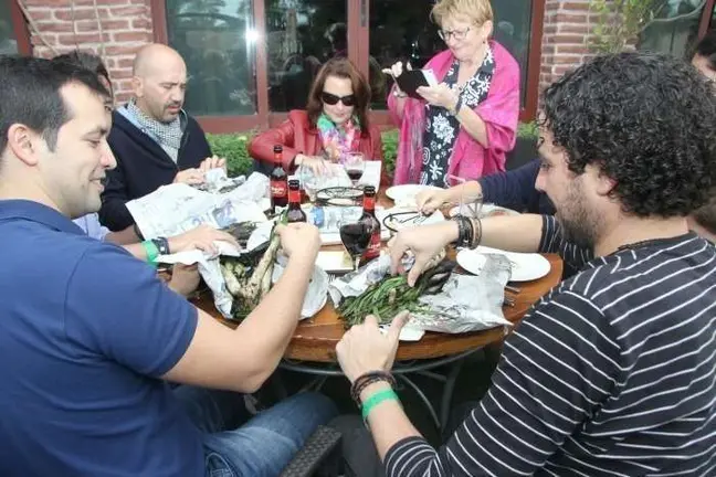 Los comensales degustan los calçots una vez servidos en la mesa envueltos en papel de periódico. (EL CORREO)