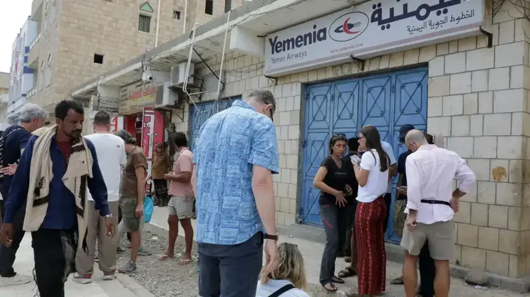 Turistas, ante las oficinas de la compal&iacute;a a&eacute;rea Yemenia. (RRSS)