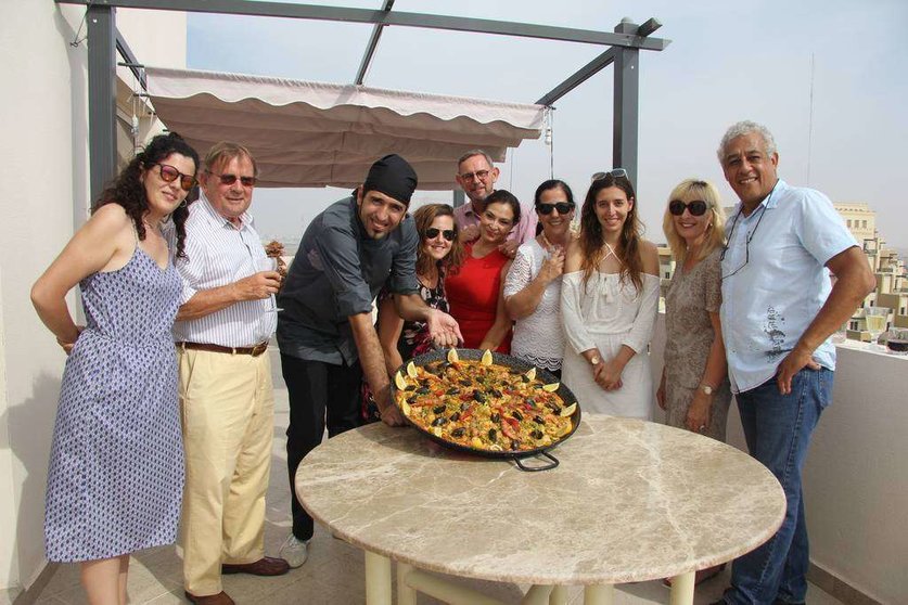 El chef Luis Ezqueta, acompañado del grupo de agradecidos comensales, muestra la paella que preparó en Al Marjan Island. (EL CORREO)