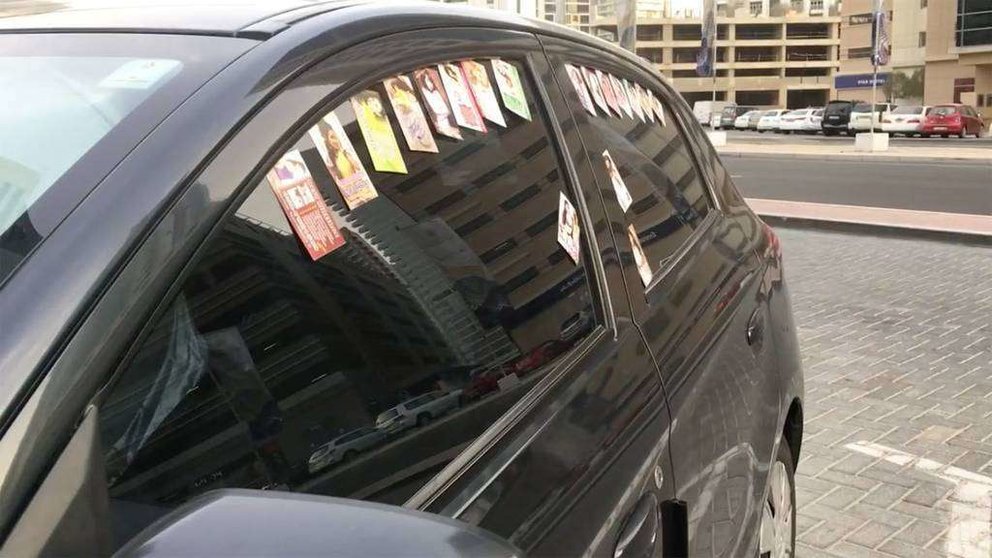Un coche aparcado en la zona de Al Barsha decorado con las tarjetas de masaje. (Fuente externa)