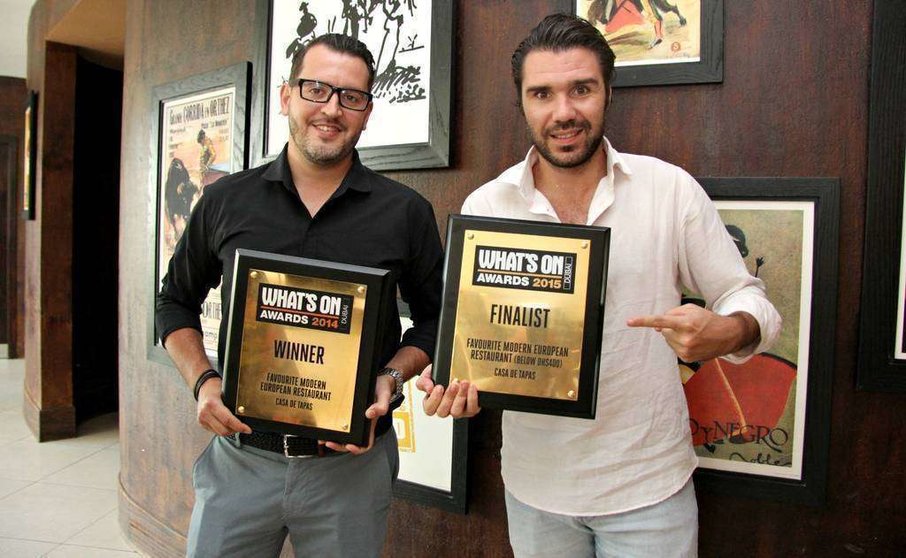 Marc Ledesma -izquierda- y Borja Vela muestran anteriores reconocimientos de los premios What's On a Casa de Tapas. (EL CORREO)