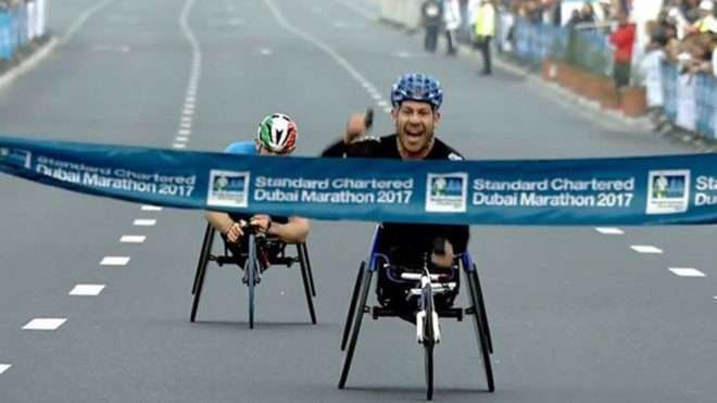 Rafa Botello cruzando el primero la línea de meta en el maratón de Dubai.