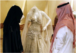 Una pareja saudí observa un traje de novia.