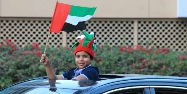 Un niño enarbola una bandera de Emiratos Árabes en el Día Nacional de 2012. (Celia HK)