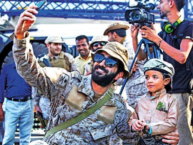 Un soldado saudí se fotografía con un niño yemení en Adén.