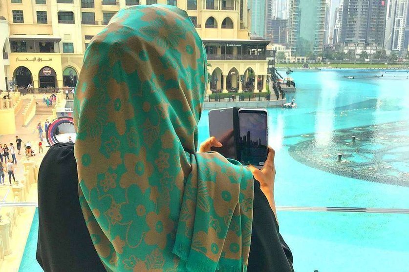 Una mujer toma desde Dubai Mall imágenes de la Plaza de la Fuente en Dubai, situada ante el Burj Khalifa. (EL CORREO)