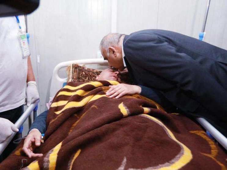 El primer ministro iraquí, Adel Abdul Mahdi, besa a uno de los supervivientes del accidente de Irak.