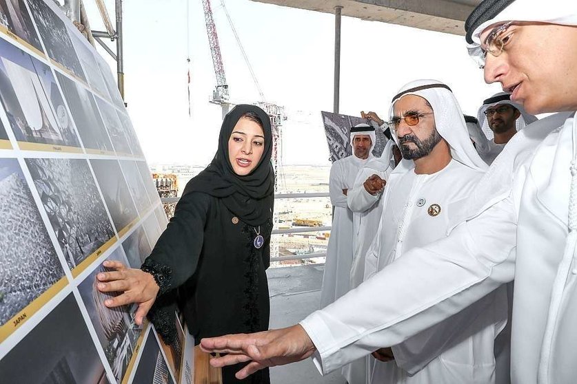 El jeque Mohammed bin Rashid Al Maktoum, vicepresidente y primer ministro de Emiratos Árabes Unidos y gobernante de Dubai -en el centro-, atiende en el recinto de la Expo 2020 las explicaciones de la ministra de Estado de Cooperación Internacional. (WAM)