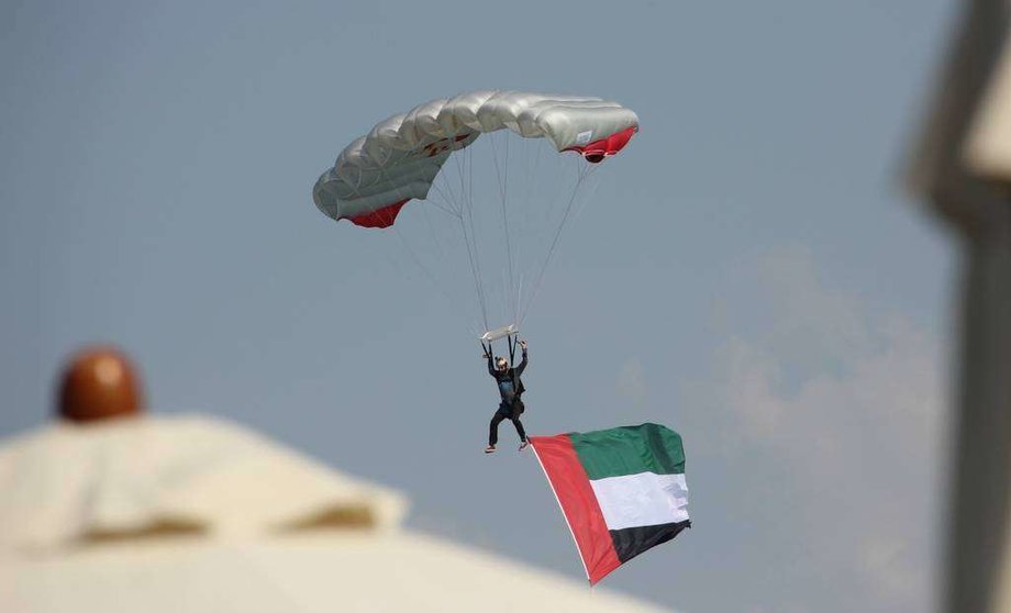 Un paracaidista porta la bandera de Emiratos Árabes en su descenso hacia la Marina de Abu Dhabi. (EL CORREO)
