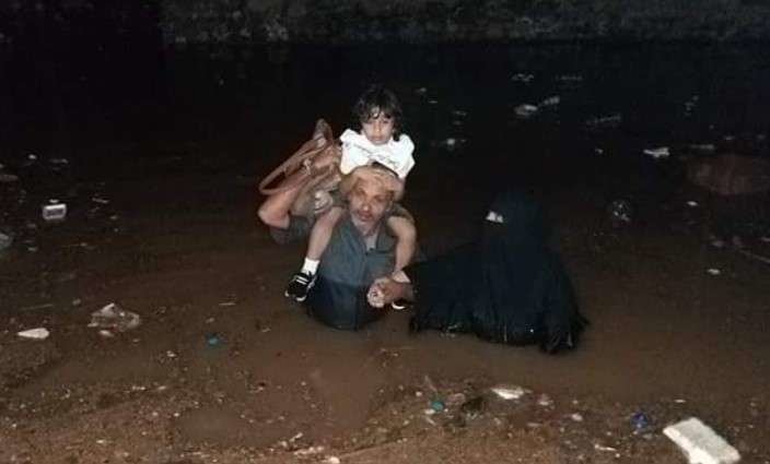 Una familia huye de las inundaciones en Adén.