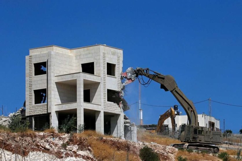 Una topadora israelí demuele un edificio palestino en Sur Baher .(REUTERS/Mussa Qawasma)