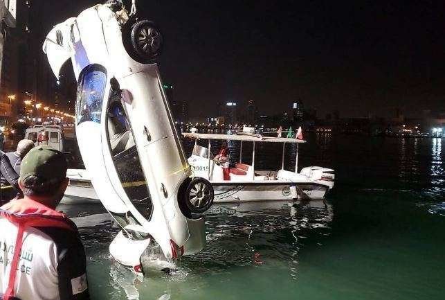 Una grúa saca el coche del Creek de Dubai.