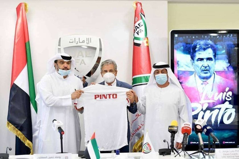 Jorge Luis Pinto muestra la camiseta de la Selección de Emiratos junto a directivos del equipo. (Cedida)