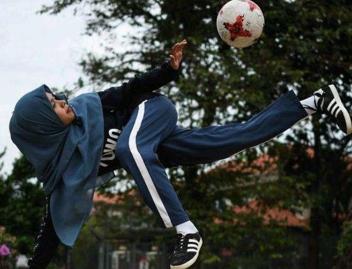 Una mujer árabe juega al fútbol.