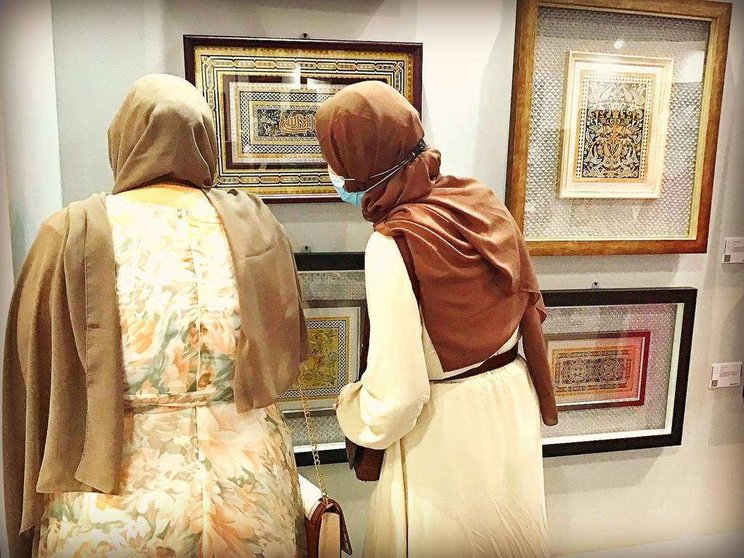 Mujeres árabes observan con toda atención los guadamecíes expuestos por José Carlos Villarejo en Dubai. (EL CORREO)