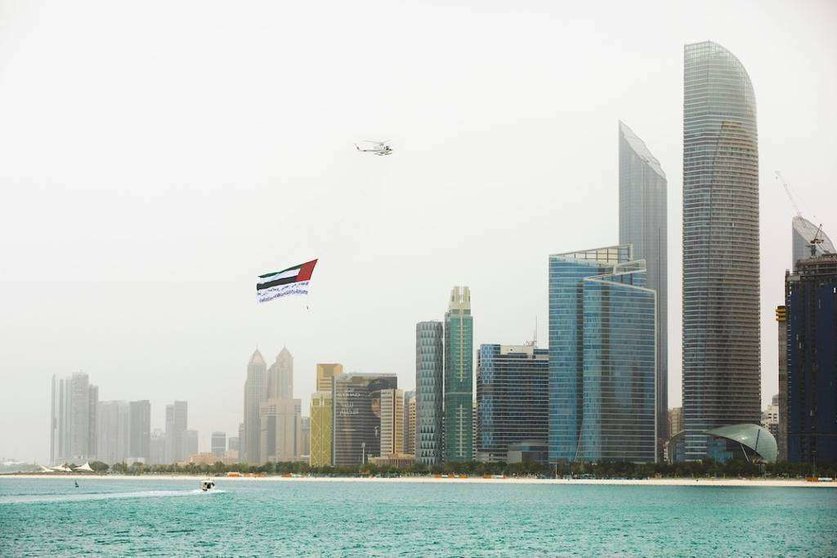 El helicóptero con la bandera de EAU sobrevuela Abu Dhabi. (WAM)