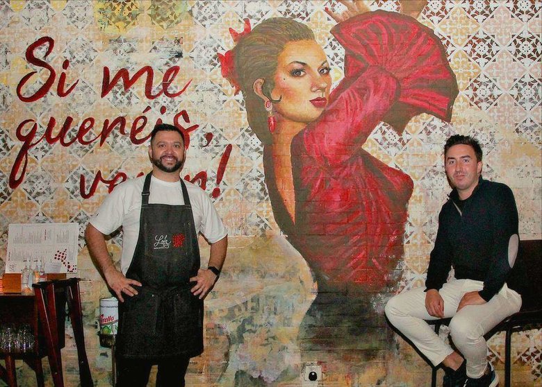 Daniel Pérez Delgado, chef de 'Lola' -izquierda-, Lloy Rubio, director general de la taberna española, junto al impresionante mural de Lola Flores que preside el 'Jamón Bar' de establecimiento. (EL CORREO)