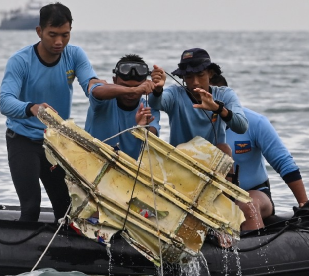 Rescatistas encuentran en el mar partes del avión. (AFP)
