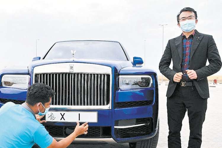 El empresario chino con su Rolls y su matrícula. (Gulftoday)