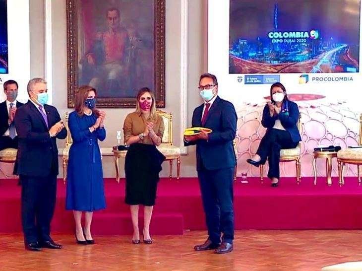 El presidente Iván Duque entrega al comisionario de la Expo 2020 Dubai Juan Cavelier la bandera que presidirá el pabellón de Colombia. (Twitter)