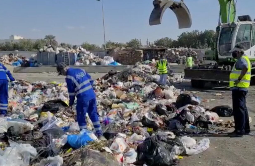 Los trabajadores de la gestión de residuos en Emiratos buscan la cartera. (Fuente externa)