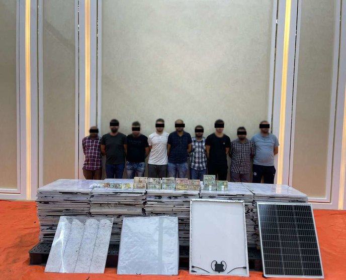 Los detenidos junto a la droga y los paneles solares. (Dubai Police)