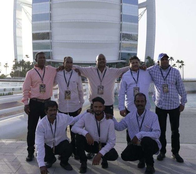 Los trabajadores agraciados ante el Burj Al Arab. (Fuente externa)