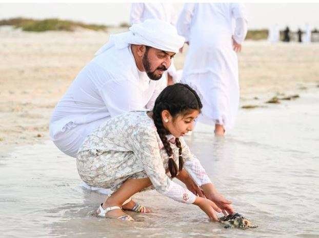 El jeque Hamdan bin Zayed  y una joven miembro de su familia liberan tortugas en Saadiyat Island. (Oficina de Medios de Abu Dhabi)