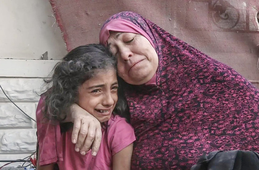 Una mujer palestina y su pequeña hija lloran por la destrucción de sus casa por bombardeo israelí en la Franja de Gaza. (@HoyPalestina)