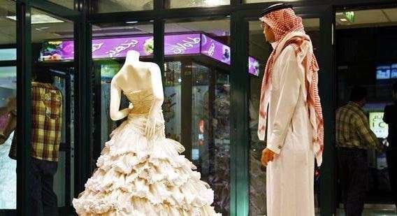 Un saudí observa en un escaparate de Riad un vestido de novia.