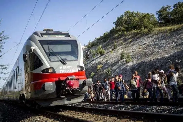 Una imagen de los migrantes caminado a lado de la v&iacute;a ante la negativa de ser transportados en los trenes.