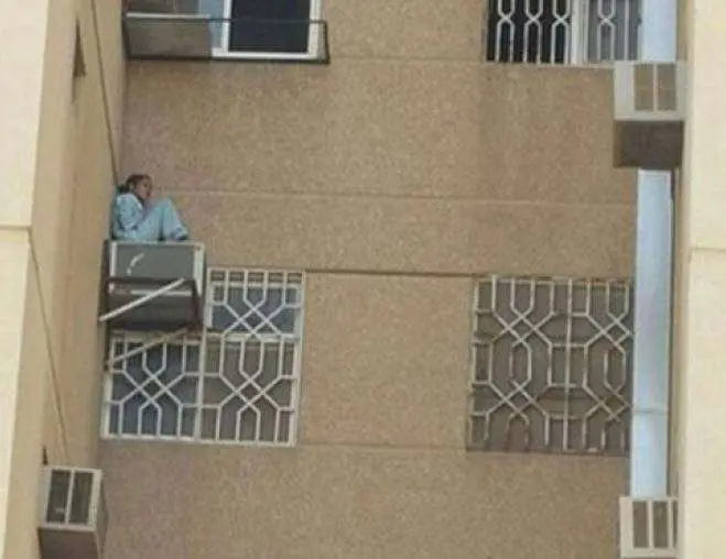 La empleada sentada en el aparato de aire acondicionado del sexto piso.