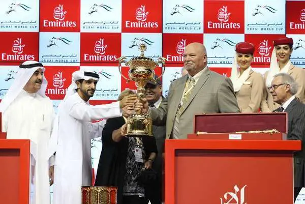 El jeque Hamdan entrega la copa al propietario de California Chrome. (Wam)