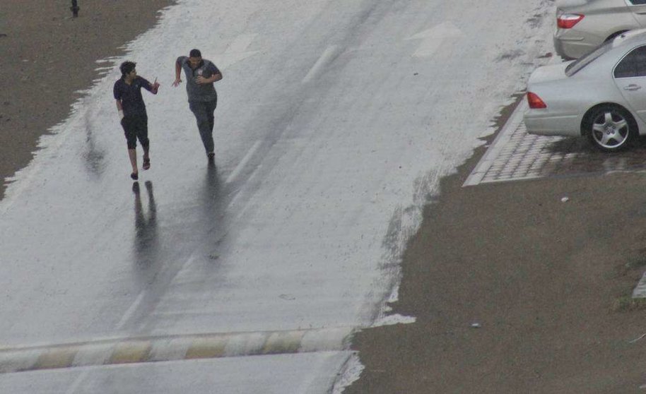 Dos jóvenes corren para ponerse a resguardo de la lluvia. (EL CORREO)
