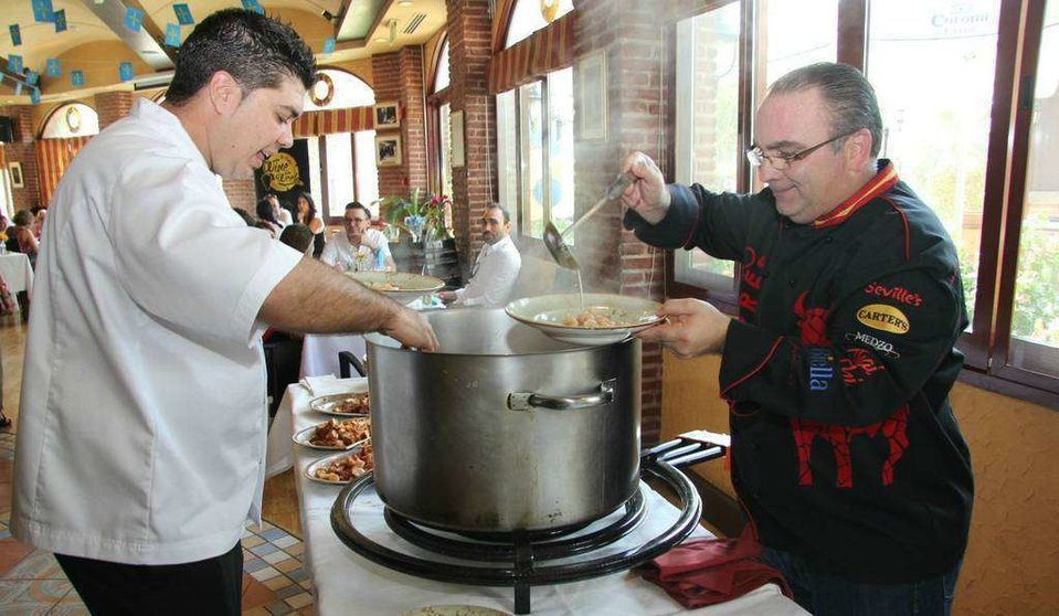 Mariano Andrés -derecha- y José Vicente sirven la fabada en el Día de Asturias. (EL CORREO) 