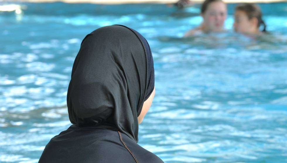 Una mujer en burkini en una piscina.