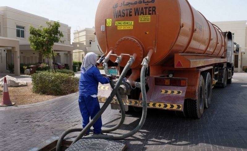 Un trabajador manipula un camión cisterna en una urbanización de EAU (The National).,