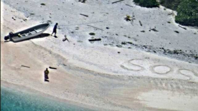 La foto de la US Navy muestra la palabra de socorro en la arena.