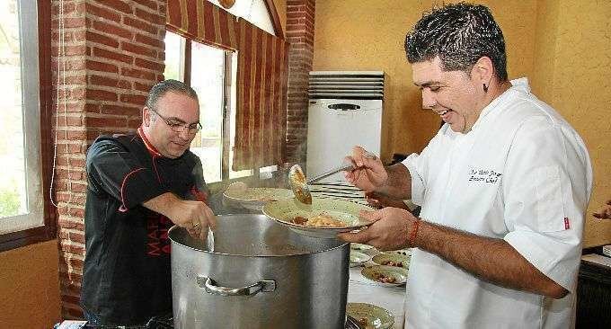 Mariano Andrés -izquierda- y José Vicente sirven la fabada en el Día de Asturias 