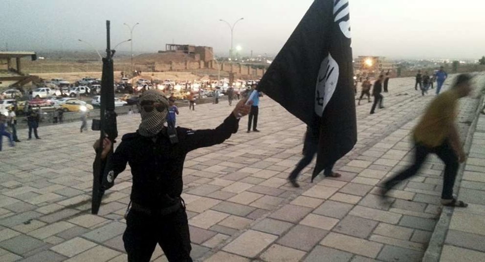 Un enmascarado con una bandera de Daesh.