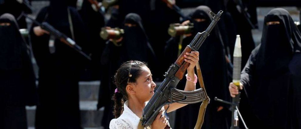 En la foto de Reuters se observa a mujeres y una niña portando armas pesadas.