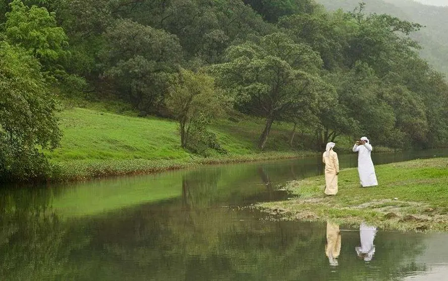 Dos árabes toman una foto en la turística zona de Salalah en Omán.