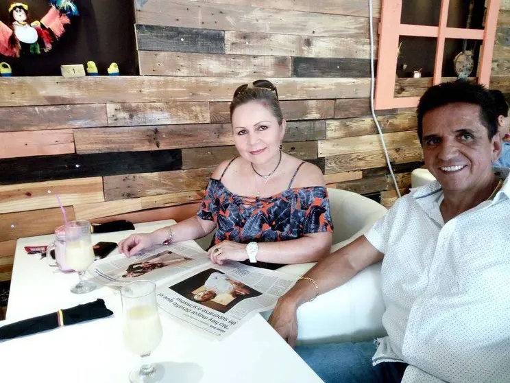 Los colombianos Cony y José Ramiro leen EL CORREO DEL GOLFO en el restaurante La Hacienda mientras aguardan que les sirvan la frijolada. (EL CORREO)