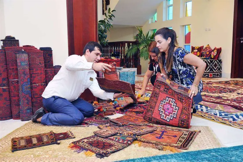Invitadas a la exposición examinan el excelente trabajo llevado a cabo por las mujeres afganas en la confección de alfombras. (Manaf K. Abbas)