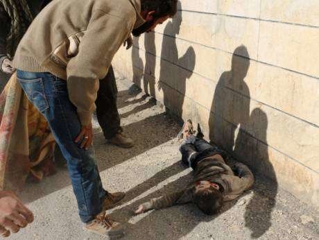 En la imagen de AFP, un hombre observa a un niño muerto en un barrio de Alepo.
